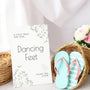 A stylish wedding sign reading "A little treat for your dancing feet, please take a pair", displayed next to a basket of flip-flops for guests. The design features elegant typography, perfect for a wedding reception.