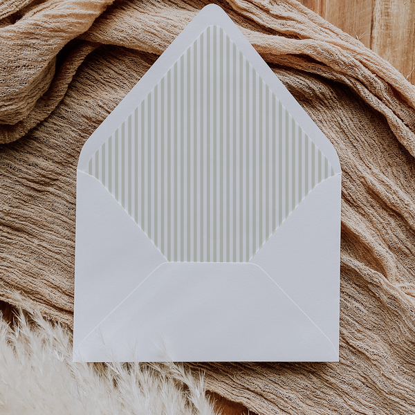 A flat lay of elegant wedding invitation envelopes, partially open to reveal beautifully designed envelope liners in various styles, including floral, modern, and classic patterns. The envelope inserts add a touch of luxury and sophistication to the stationery set.