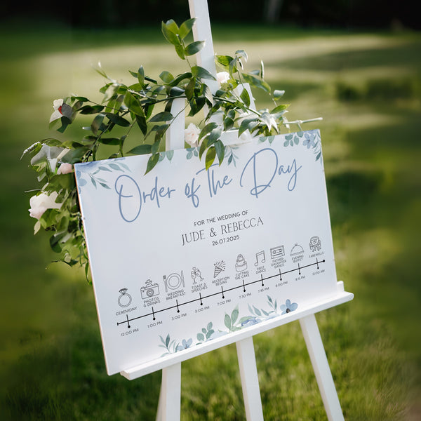 Blue floral wedding order of the day sign - white crisp background, sophisticated black text, with elegant blue florals adorned on the top and bottom edge. The perfect customised wedding signs.