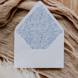 A flat lay of elegant wedding invitation envelopes, partially open to reveal beautifully designed envelope liners in various styles, including floral, modern, and classic patterns. The envelope inserts add a touch of luxury and sophistication to the stationery set.