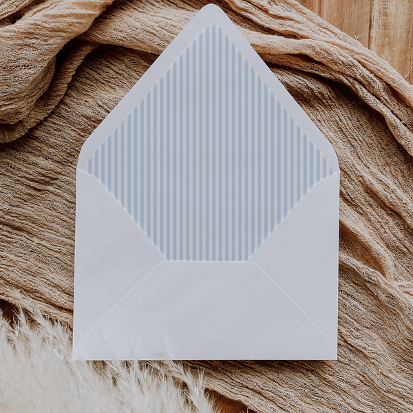A flat lay of elegant wedding invitation envelopes, partially open to reveal beautifully designed envelope liners in various styles, including floral, modern, and classic patterns. The envelope inserts add a touch of luxury and sophistication to the stationery set.