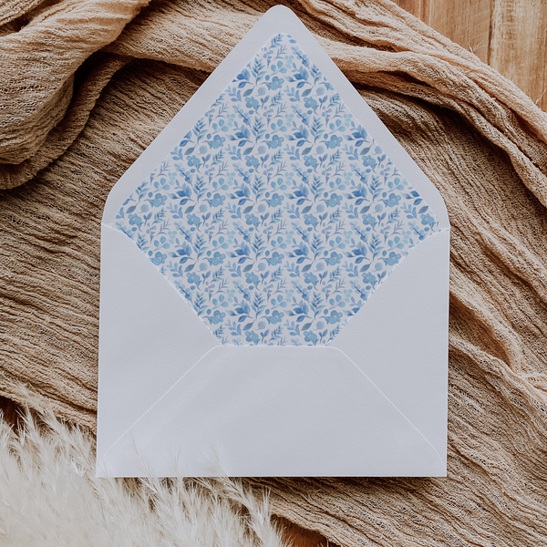 A flat lay of elegant wedding invitation envelopes, partially open to reveal beautifully designed envelope liners in various styles, including floral, modern, and classic patterns. The envelope inserts add a touch of luxury and sophistication to the stationery set.