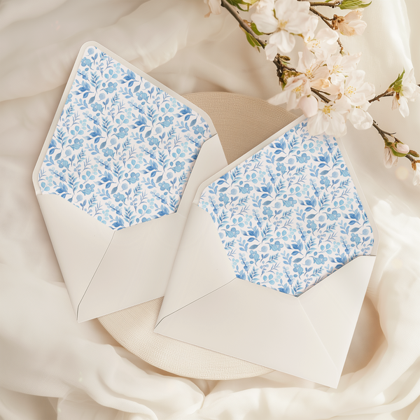 A flat lay of elegant wedding invitation envelopes, partially open to reveal beautifully designed envelope liners in various styles, including floral, modern, and classic patterns. The envelope inserts add a touch of luxury and sophistication to the stationery set.