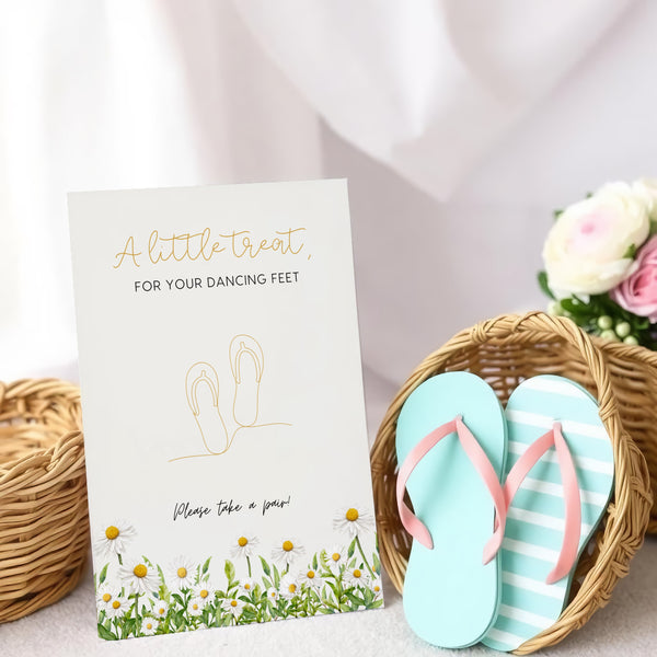 A stylish wedding sign reading "A little treat for your dancing feet, please take a pair", displayed next to a basket of flip-flops for guests. The design features elegant typography, perfect for a wedding reception.