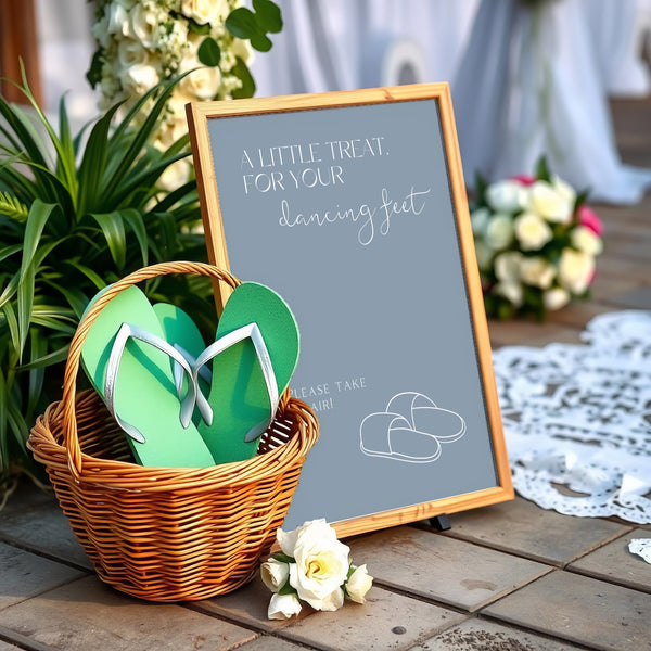 A stylish wedding sign reading "A little treat for your dancing feet, please take a pair", displayed next to a basket of flip-flops for guests. The design features elegant typography, perfect for a wedding reception.