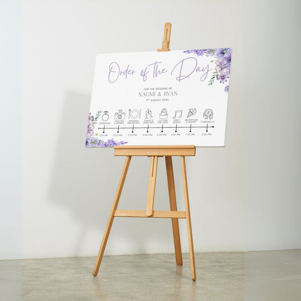 lilac floral order of the day board for weddings - a personalised order of events sign, with a crisp white background and sophisticated black text, adorned with lilac and lavender florals.