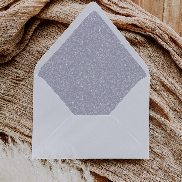 A flat lay of elegant wedding invitation envelopes, partially open to reveal beautifully designed envelope liners in various styles, including floral, modern, and classic patterns. The envelope inserts add a touch of luxury and sophistication to the stationery set.