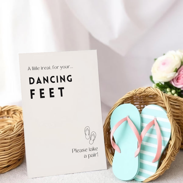 A stylish wedding sign reading "A little treat for your dancing feet, please take a pair", displayed next to a basket of flip-flops for guests. The design features elegant typography, perfect for a wedding reception.