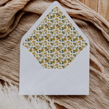 A flat lay of elegant wedding invitation envelopes, partially open to reveal beautifully designed envelope liners in various styles, including floral, modern, and classic patterns. The envelope inserts add a touch of luxury and sophistication to the stationery set.