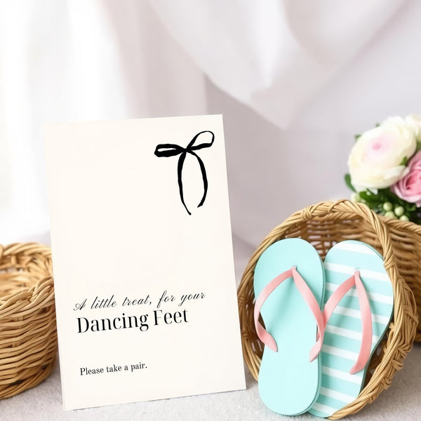 A stylish wedding sign reading "A little treat for your dancing feet, please take a pair", displayed next to a basket of flip-flops for guests. The design features elegant typography, perfect for a wedding reception.