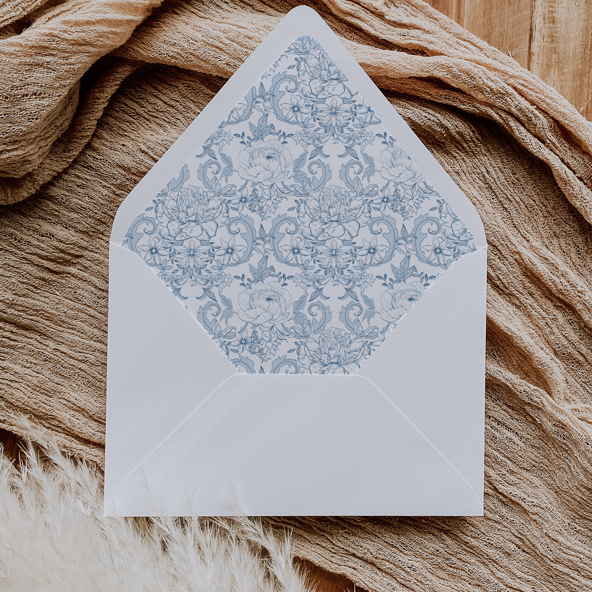 A flat lay of elegant wedding invitation envelopes, partially open to reveal beautifully designed envelope liners in various styles, including floral, modern, and classic patterns. The envelope inserts add a touch of luxury and sophistication to the stationery set.