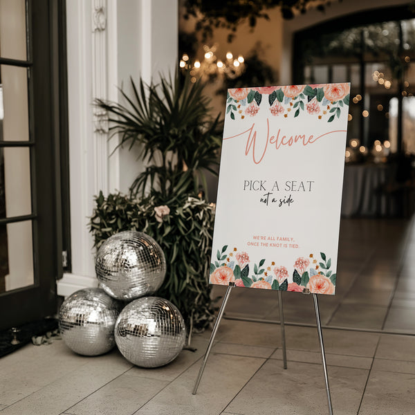 peach floral pick a seat not a side wedding ceremony sign - a personalised "pick  seat, not a side" wedding welcome sign, with a crisp white background and elegant blush peach text, adorned with soft pastel peach floral blooms