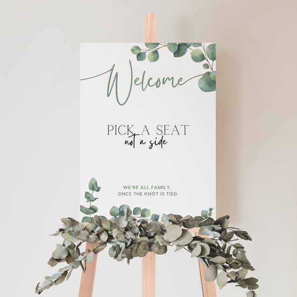 eucalyptus pick a seat not a side wedding ceremony sign - a personalised "pick seat, not a side" wedding welcome sign, with a crisp white background and elegant green text, adorned with eucalyptus foliage