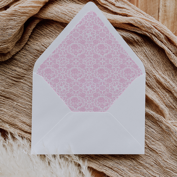 A flat lay of elegant wedding invitation envelopes, partially open to reveal beautifully designed envelope liners in various styles, including floral, modern, and classic patterns. The envelope inserts add a touch of luxury and sophistication to the stationery set.