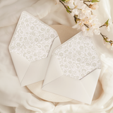 A flat lay of elegant wedding invitation envelopes, partially open to reveal beautifully designed envelope liners in various styles, including floral, modern, and classic patterns. The envelope inserts add a touch of luxury and sophistication to the stationery set.