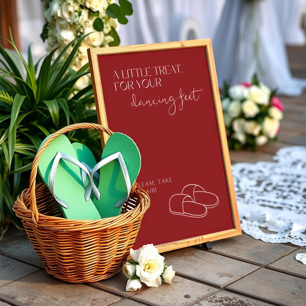 A stylish wedding sign reading "A little treat for your dancing feet, please take a pair", displayed next to a basket of flip-flops for guests. The design features elegant typography, perfect for a wedding reception.