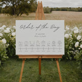 dreamy white order of the day wedding board, with sophisticated and delicate black text, in a calligraphy font