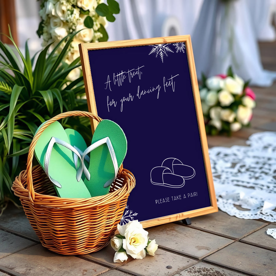 A stylish wedding sign reading "A little treat for your dancing feet, please take a pair", displayed next to a basket of flip-flops for guests. The design features elegant typography, perfect for a wedding reception.