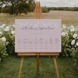 pastel pink wedding order of the day sign, with beautiful calligraphy text and a floral white header.