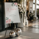 Pink Rose Floral wedding welcome sign in portrait orientation. A beautiful wedding welcome board, personalised with names and a date, adorned with pink roses and soft blush hues.