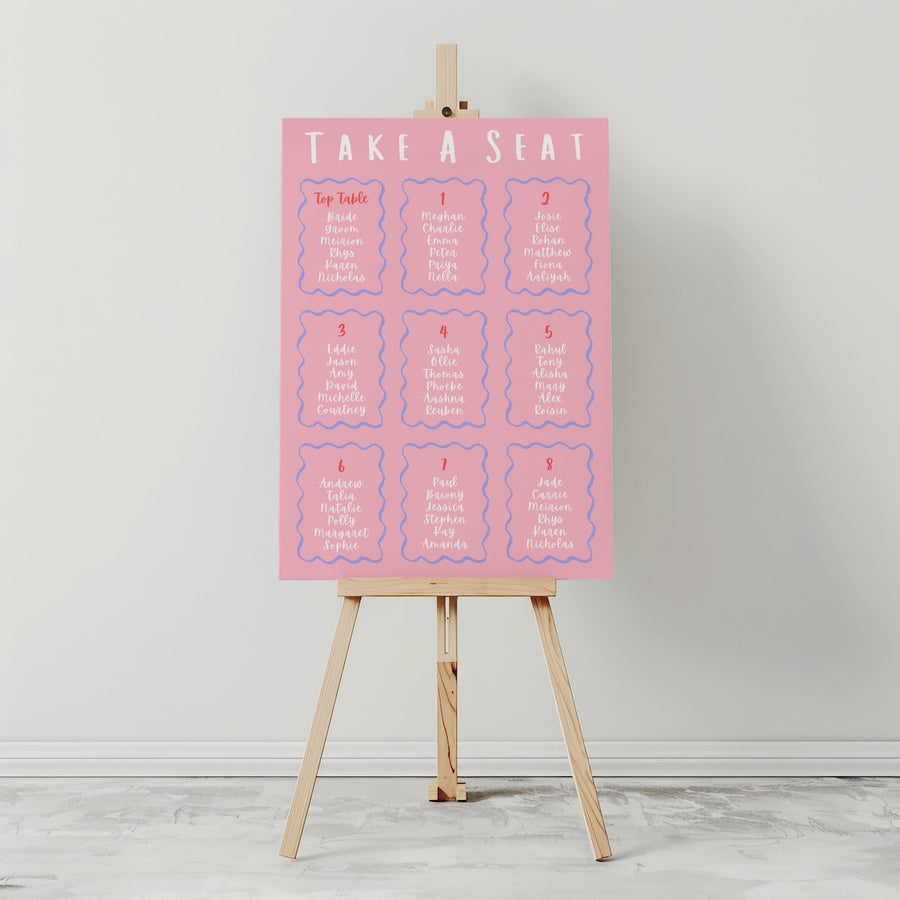 Pink seating chart on an easel against a white wall