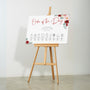 romantic red floral order of the day wedding sign - a crisp white background, with elegant black text and soft, romantic red blooms.