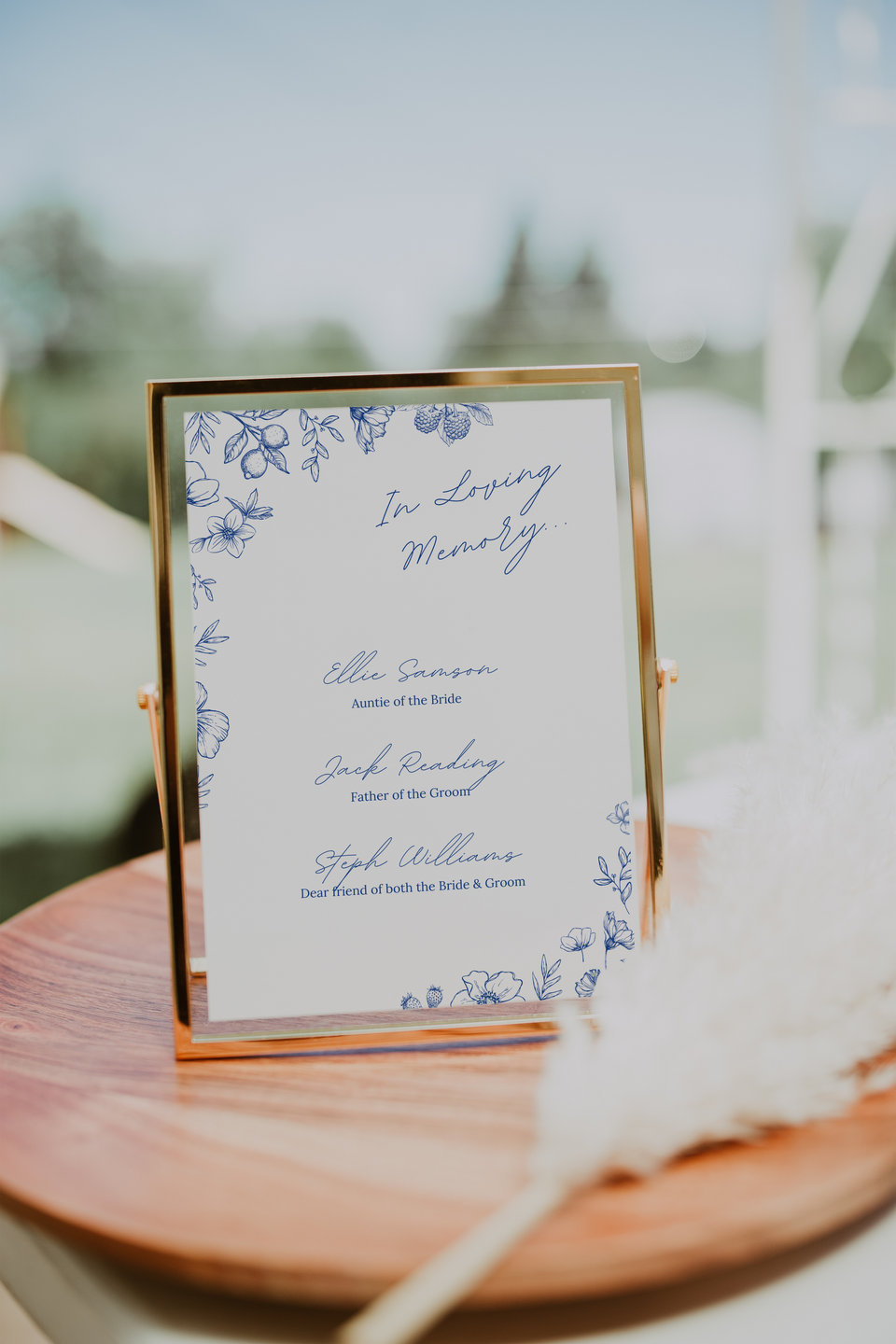 Santorini in loving memory wedding table sign with blue botanical sketches and elegant handwritten script