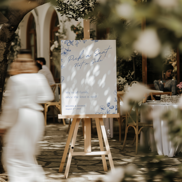 Santorini pick a seat not a side wedding sign with blue botanical sketches and elegant handwritten script