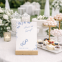 Santorini sweet table wedding sign with blue botanical sketches and elegant handwritten script
