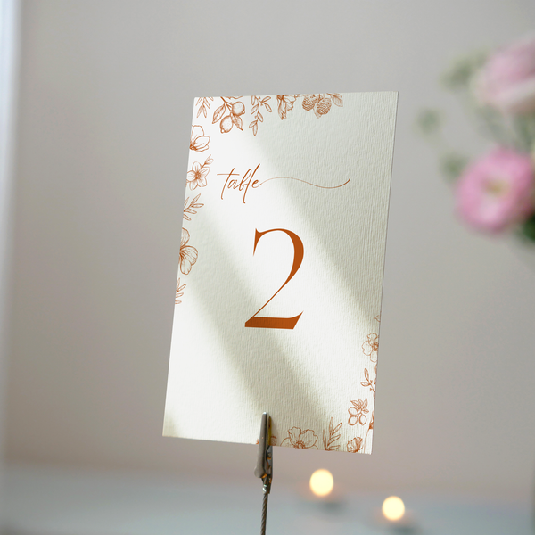 Sienna floral wedding table number card with terracotta botanical sketches and elegant boho typography