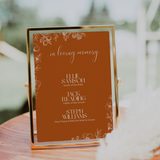 Toasted Amber in loving memory wedding table sign with burnt orange background and white botanical line art