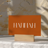 Toasted Amber wedding place card with burnt orange background and white botanical line art