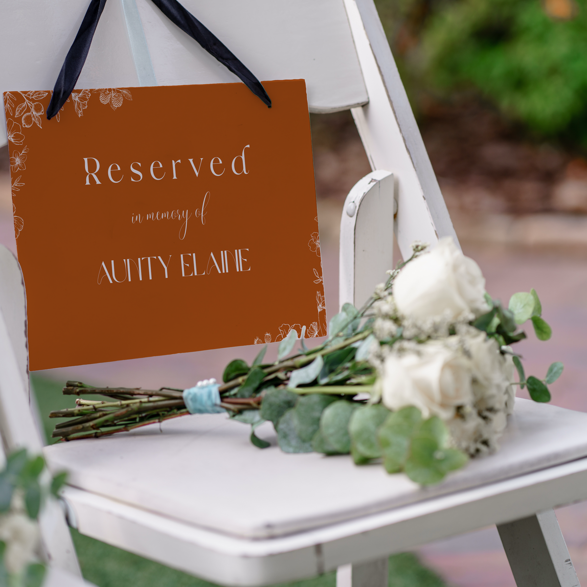 Toasted Amber reserved in memory wedding chair sign with burnt orange background and white botanical line art