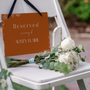 Toasted Amber reserved in memory wedding chair sign with burnt orange background and white botanical line art
