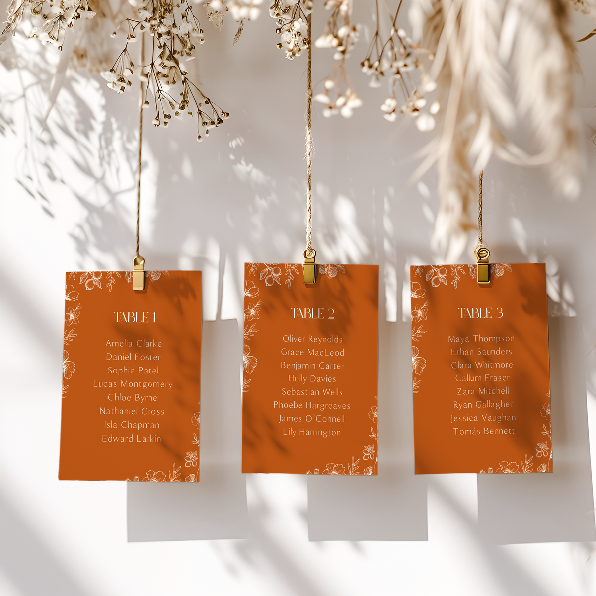 Toasted Amber wedding seating plan cards with burnt orange background and white botanical line art