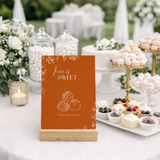 Toasted Amber sweet table wedding sign with burnt orange background and white botanical line art