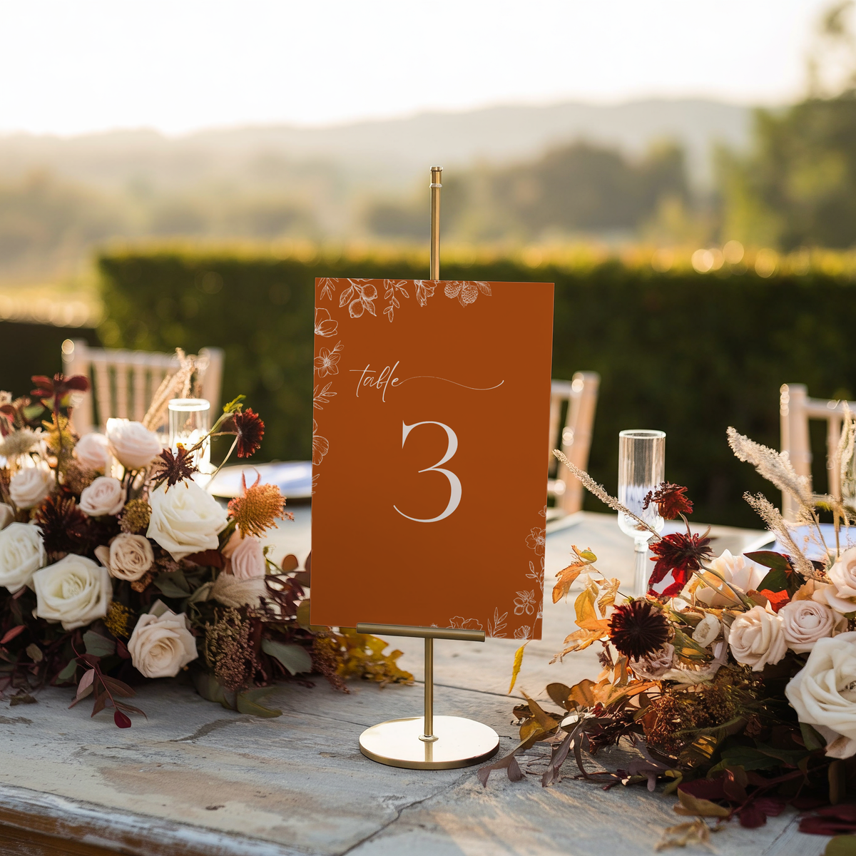 Toasted Amber wedding table number card with burnt orange background and white botanical line art
