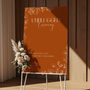 Toasted Amber unplugged ceremony wedding sign with burnt orange background and white botanical line art